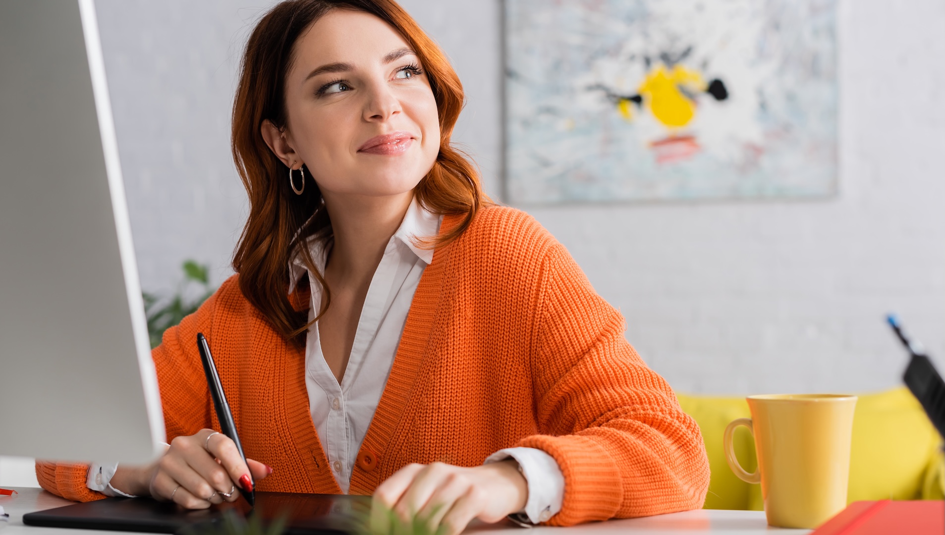 Woman freelancer workign at desk and looking to the side